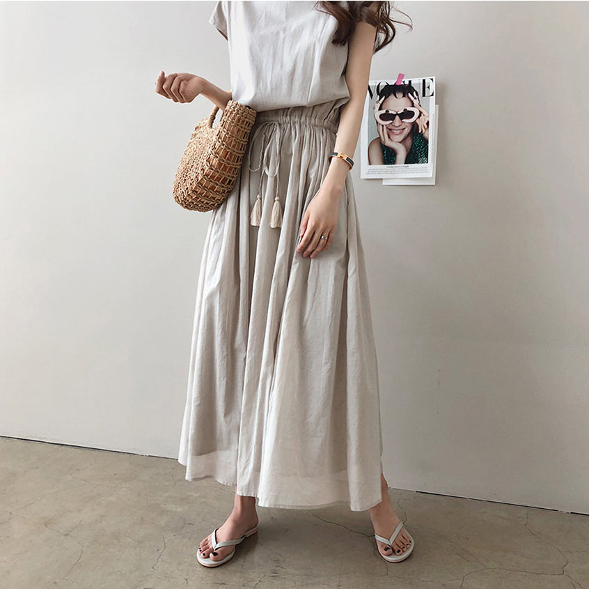 a woman standing in front of a white wall